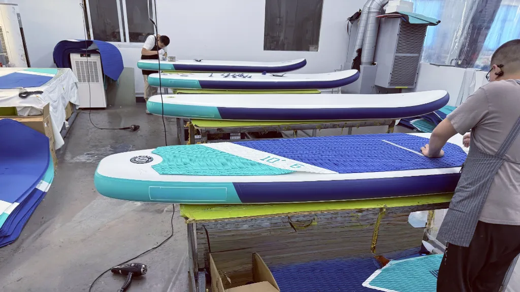 Skilled technicians hand-sealing the seams of a custom inflatable paddle board at the Blue Rafty - inflatable boat manufacturer in china